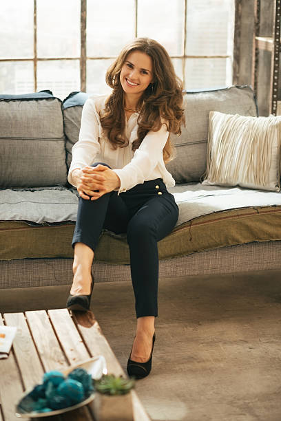 istock smiling young woman sitting on couch in loft apartment 532507397