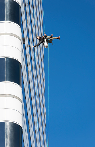 Columbia, South Carolina, USA - December 10, 2014: Man washing windows on a high rise building in downtown Columbia