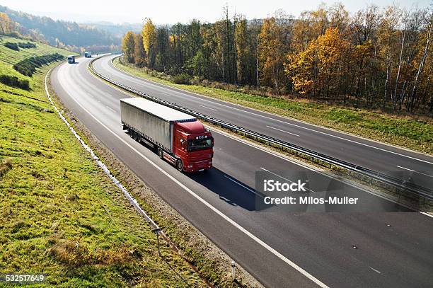 The Highway Between Forests In Fall Colors Three Trucks Stock Photo - Download Image Now