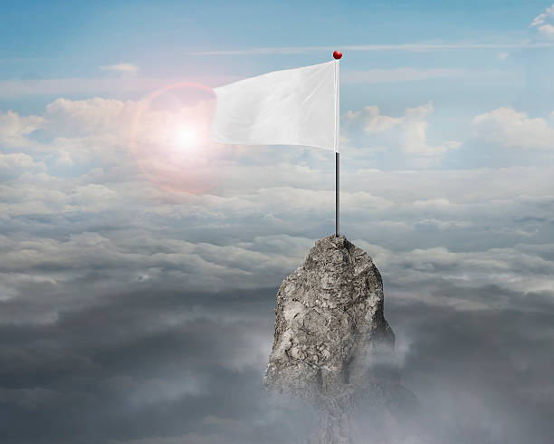 blank white flag on the mountain peak with sky cloudscape sunlight background