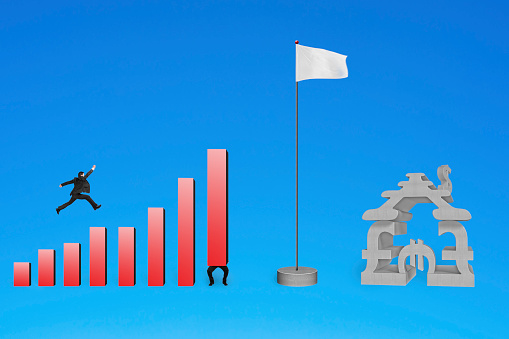 Businessman jumping over bar charts to flag with currency house isolated on blue background