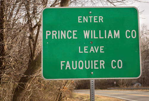 Green road sign in Virginia showing the border between Fauquier and Prince William Counties