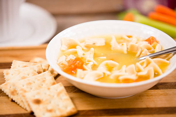 istock Chicken noodle soup in bowl on table. Spoon, crackers, ingredients. 532521361