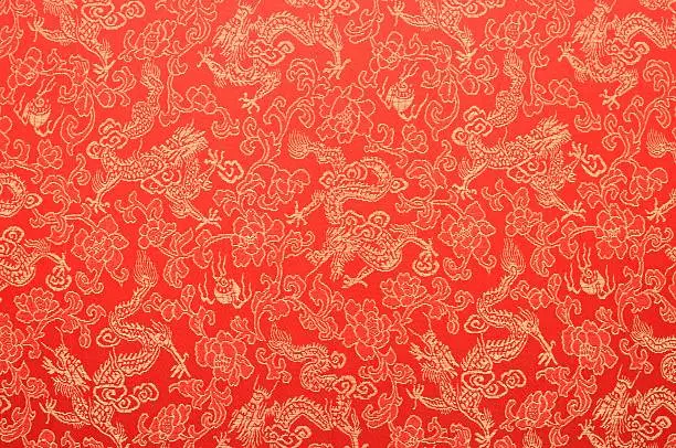Fragment of red chinese silk with golden dragons and flowers