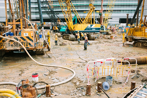 Hong Kong, Сhina - November 10, 2014: Industry workers and heavy plant on a large construction site, Hong Kong.