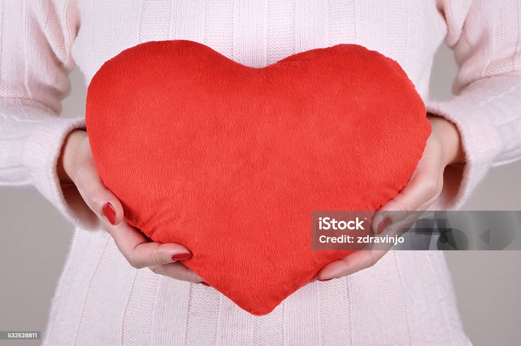 Woman holding a plush red heart Woman holding a plush red heart on Valentine’s day    Heart Shape Stock Photo