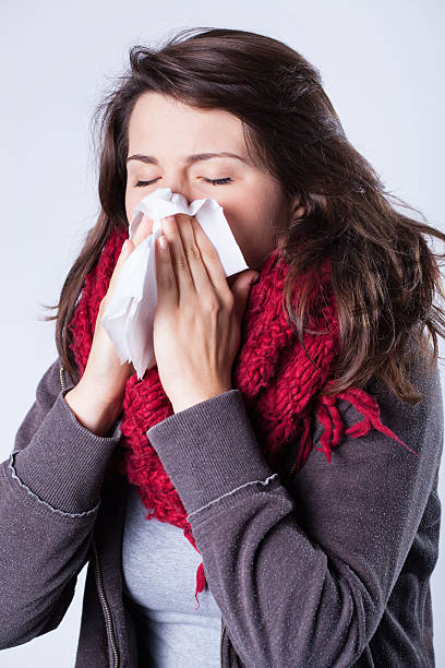 istock Woman in scarf sneezing 532531147
