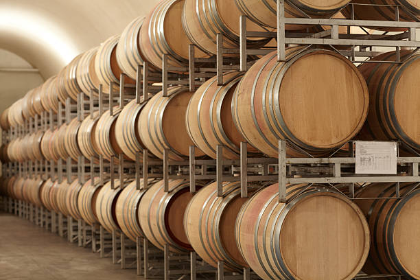 Mass producing wine Stacked barrels of wine at a wine distillery wine shipping stock pictures, royalty-free photos & images