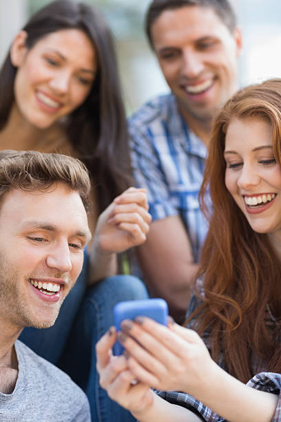 istock Happy students looking at smartphone outside on campus 532533669