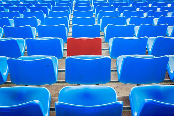 istock An empty red chair arounded by blue chairs 532534579