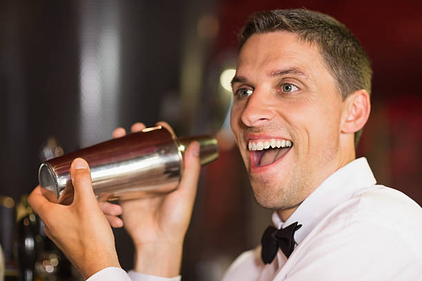 istock Handsome barman smiling at camera making a cocktail 532545841