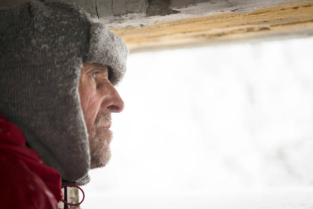 Senior Man Looking  through Great War's Bunker Porthole , Snowing, Europe