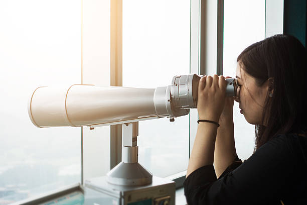 istock Young tourist using telescope looking cityscape 532548060
