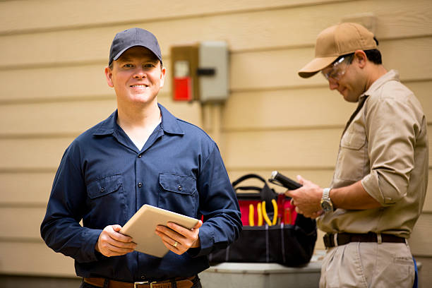 istock Air conditioner repairmen work on home unit. Blue collar workers. 532549597