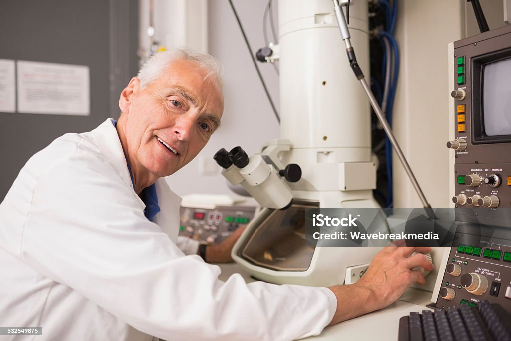Biochemist using large microscope and computer Biochemist using large microscope and computer at the university 2015 Stock Photo