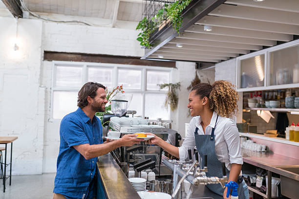 istock Aboriginal Female Barista Serving Coffee to Customer 532550496