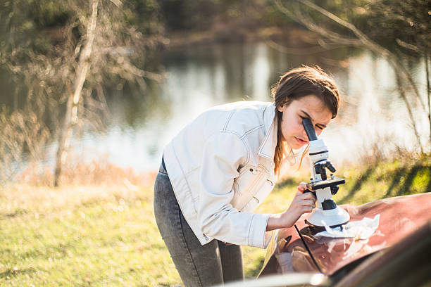 istock Teenage girl make outdoors scientific project with microscope 532550604