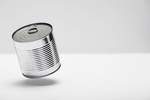 Tin can hanging over white table in a bright / white environment