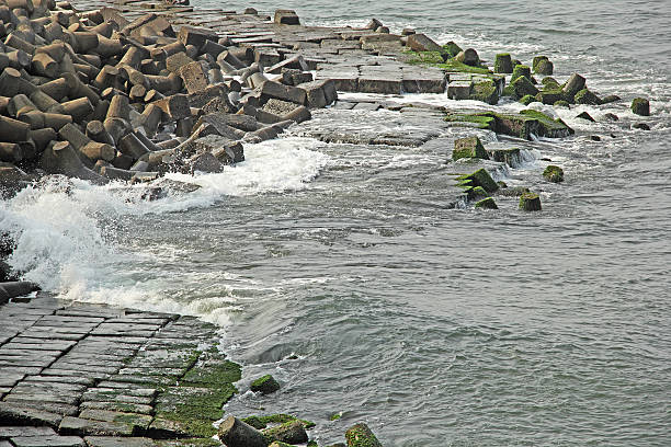 onde ultime notizie in fatto di cemento tetrapods seawall - sea defence concrete foto e immagini stock