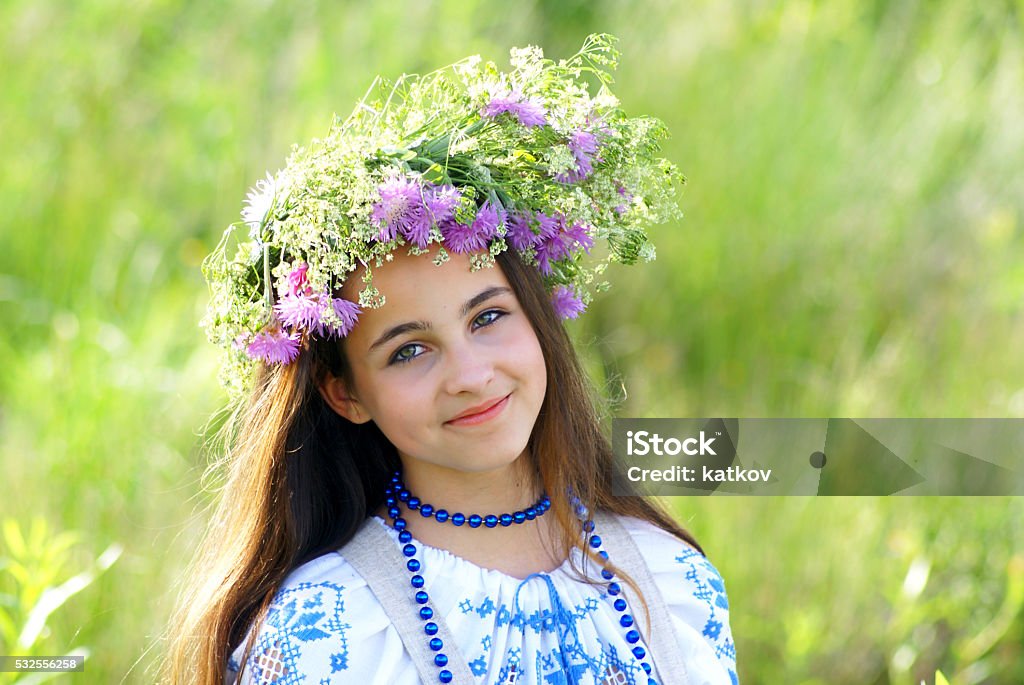 Young girl with flower garland Young russian girl with flowers outdoors Adult Stock Photo
