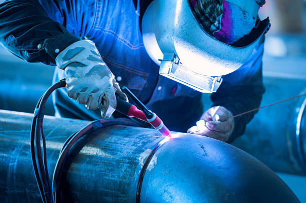 worker welding metal piping using tig welder - kaynak torcu stok fotoğraflar ve resimler