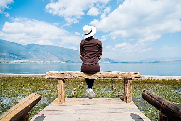 istock Young woman sitting on lakeside jetty 532562088