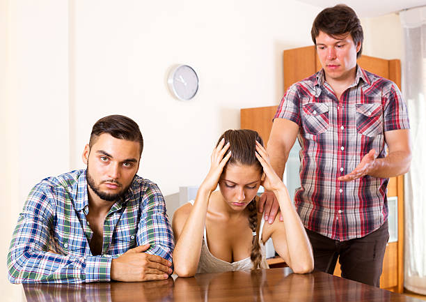 Quarrel in young polygamous family Quarrel in adult polygamous family indoors. Focus in the couple menage trois stock pictures, royalty-free photos & images