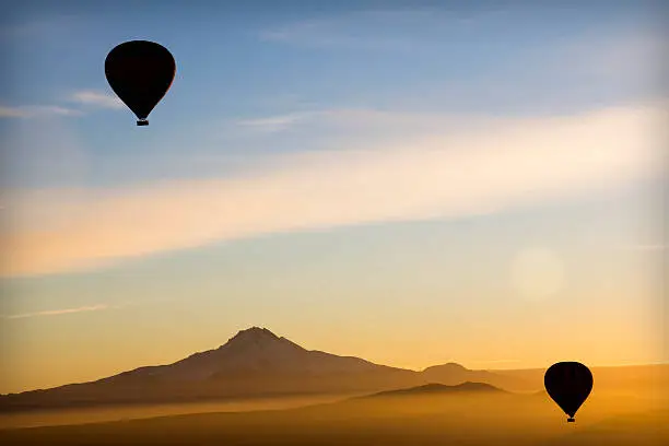 Hot Air Balloon in Capadoccia during sunrise. Blue and orange cloudy sky. Landscape.