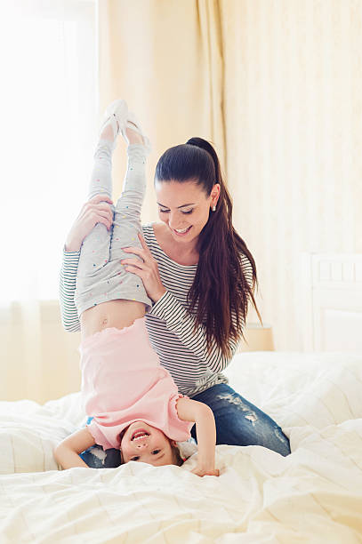 istock Mother holding her daughter doing handstand in her bedroom 532568892