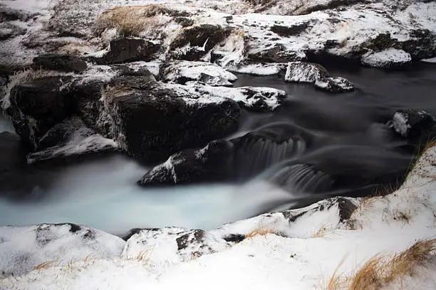 Long Exposure winter Waterfalls surrounded by snow.