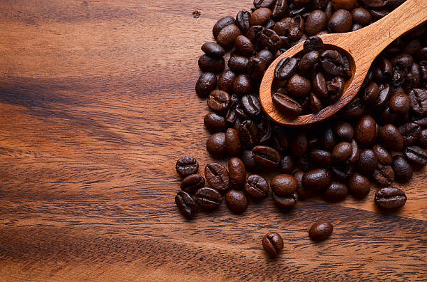 sfondo di chicchi di caffè e chicchi di caffè su sfondo in legno - coffeetree foto e immagini stock