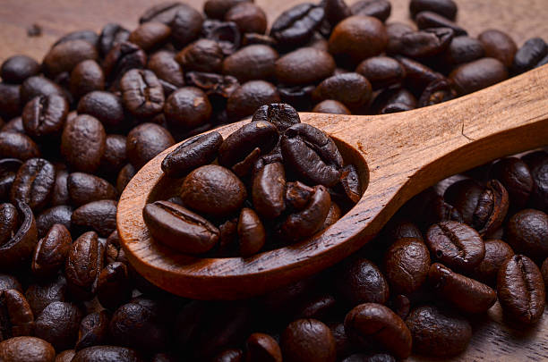 кофе в зернах. фоне/кофе в зернах. на деревянном фоне - coffeetree стоковые фото и изображения