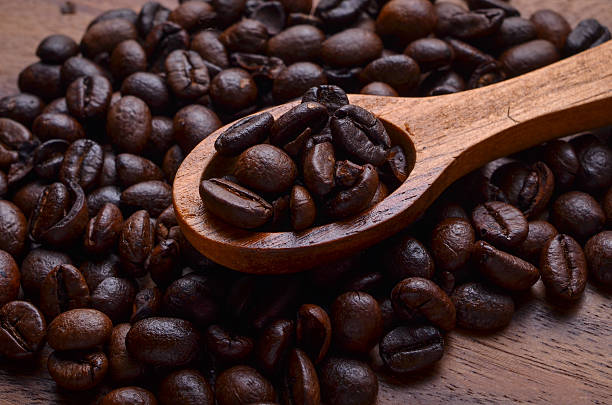 sfondo di chicchi di caffè e chicchi di caffè su sfondo in legno - coffeetree foto e immagini stock
