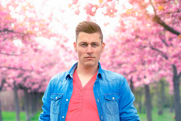 istock portrait of man outdoors with cherry blossom 532573694