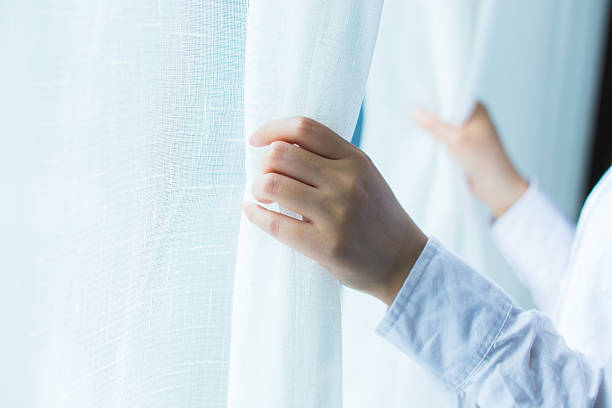 istock human hand open the curtain in the morning 532574604