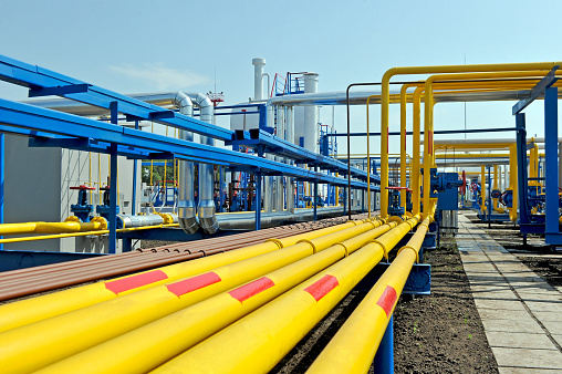 Yellow gas pipes in natural gas treatment plant in bright sunny summer day