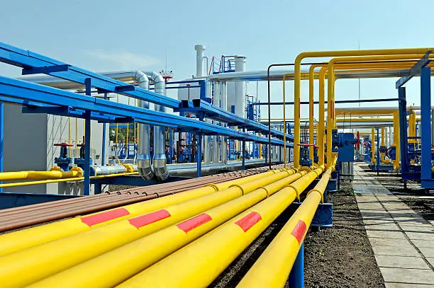 Yellow gas pipes in natural gas treatment plant in bright sunny summer day