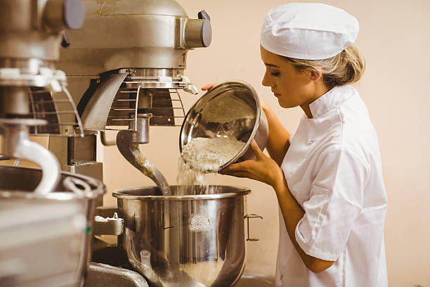 istock Baker pouring flour into large mixer 532574785