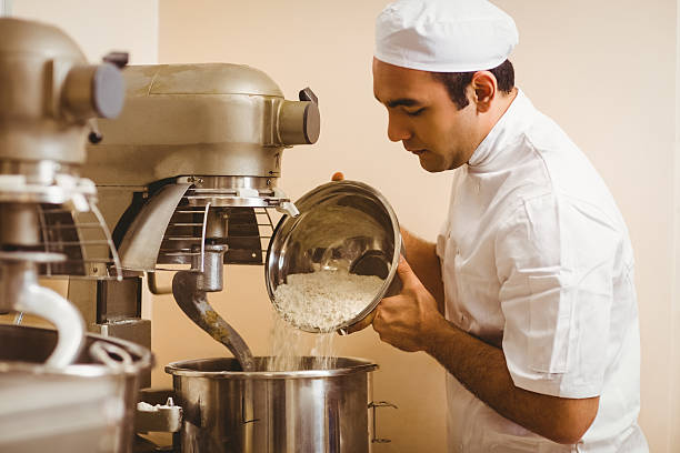 istock Baker pouring flour into large mixer 532574789