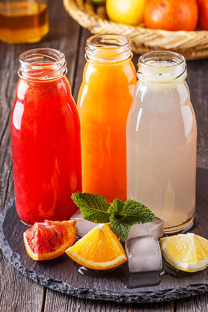 istock Fresh citrus juices on a dark wooden background. 532575010