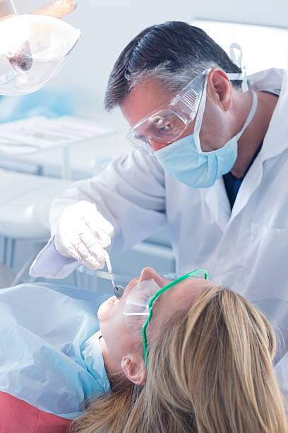 istock Dentist examining a patients teeth in the dentists chair 532576031