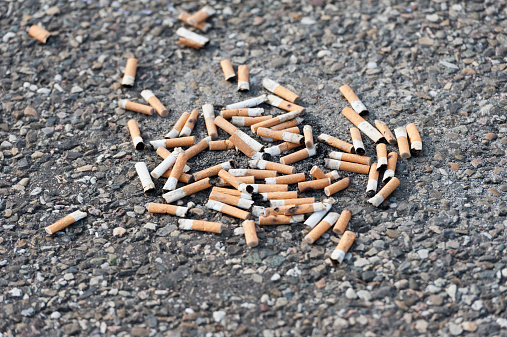 Details of cigarette butts accumulated in pedestal ashtray