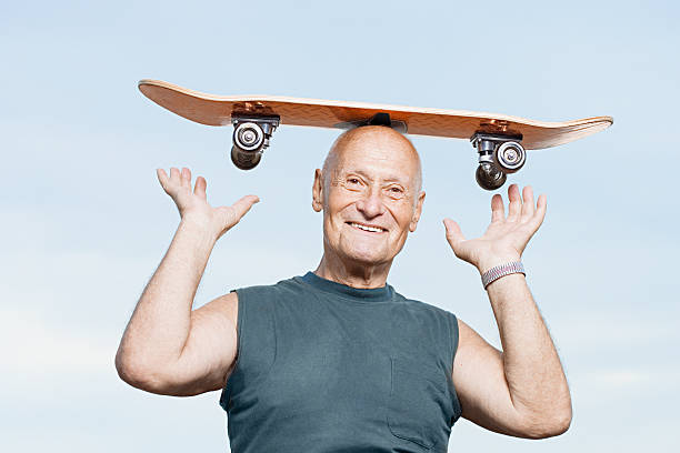 istock Senior man with a skateboard on his head 532577367