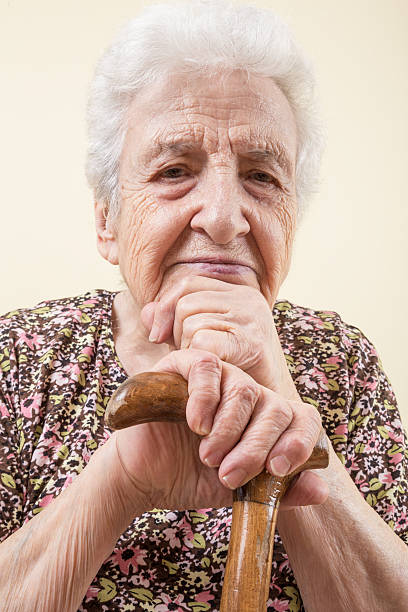 年配の女性壁に、籐製の - human hand aging process senior adult cane ストックフォトと画像