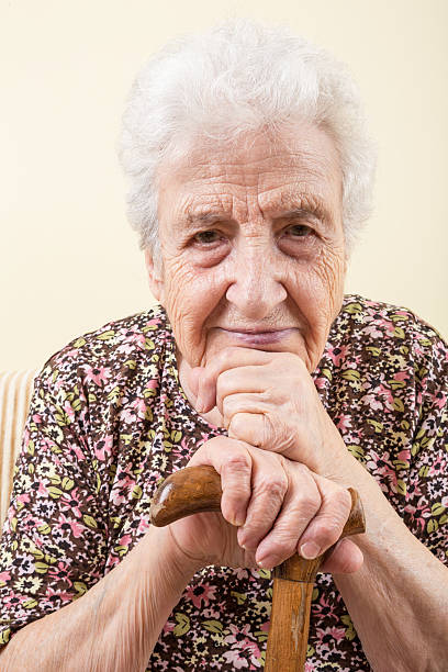 年配の女性壁に、籐製の - human hand aging process senior adult cane ストックフォトと画像