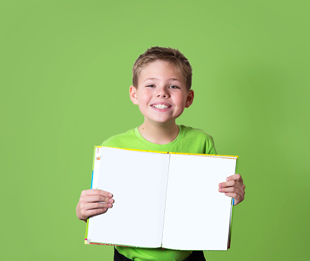 Happy boy holding book with empty copy space. Education concept.