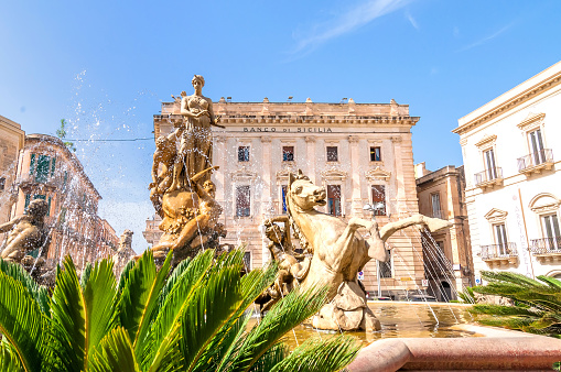 Syracuse, Italy - August 20, 2014: Artemide fountain and Archimede square in Ortigia, Syracuse, Italy. Ortigia is a small island which is the historical centre of the city of Syracuse, Sicily.
