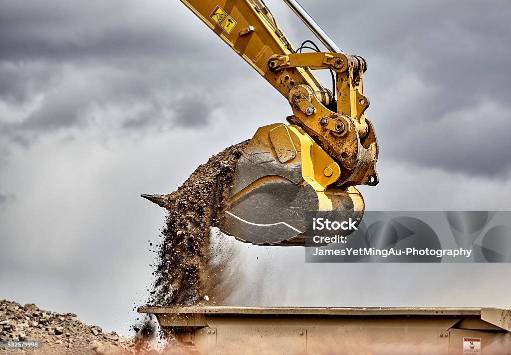 Le secteur de la Construction godet d’une excavatrice chargement gravier gros - Photo de Pelleteuse libre de droits