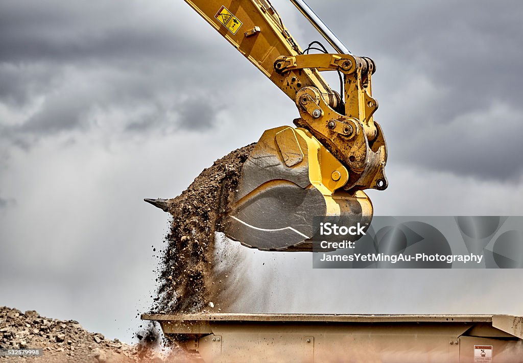 Edilizia benna dell'escavatore Caricamento ghiaia primo piano - Foto stock royalty-free di Pala meccanica