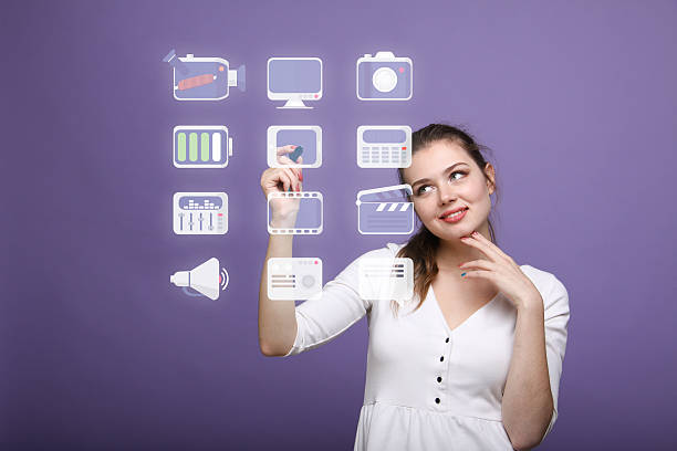 istock Woman pressing multimedia and entertainment icons on a virtual background 532580000